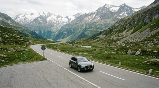 Professionnel suisse en déplacement avec son véhicule sur une route de montagne alpine